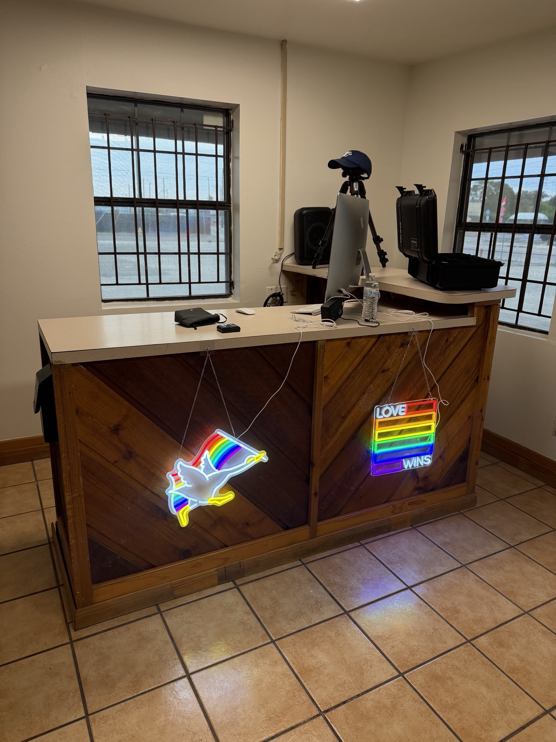 The front desk with neon rainbow goose and Love Wins signs