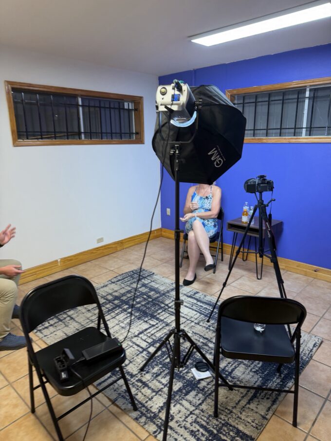An oral-history interview being recorded at The Mosaic Center, with a softbox light and a camera on a tripod